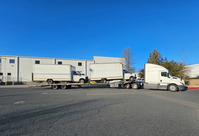 2 box trucks on semi truck hauler